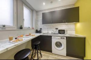 a kitchen with a sink and a washing machine at The California Paris in Champigny-sur-Marne