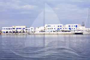 a group of white buildings on the water at Marina Cap Monastir- Appart'Hôtel in Monastir