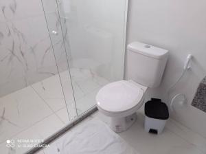 um banheiro branco com vaso sanitário e chuveiro em Cobertura em Aperibé em Aperibé