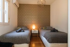 twee bedden in een kamer met een lamp op een tafel bij Casa Riad met Privé Patio in Málaga