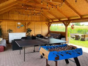 a ping pong table in the middle of a living room at Domki letniskowe "Kwatery u Skrzacika" in Sianozety +12 photos
