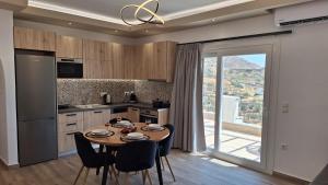 a kitchen with a table and chairs and a kitchen with a window at Alta Vista Apartments in Agkidia