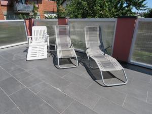 three lawn chairs and chairs sitting on a patio at Sobe apartmani Zagreb SAZ in Zagreb
