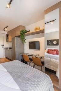 a bedroom with a bed and a kitchen with a table at Studio aconchegante I Perdizes I Nubank Parque in São Paulo