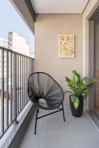 a black chair on a balcony with a plant at Studio aconchegante I Perdizes I Nubank Parque in São Paulo
