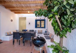 a dining room with a table and chairs and a tree at Villa Irini in Kallithea Rhodes