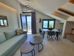a living room with a couch and a table and chairs at Sealon Suite & Loft in Limenaria
