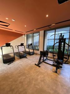 a gym with several tread machines in a room with windows at Studio aconchegante I Perdizes I Nubank Parque in São Paulo
