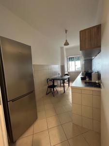 a kitchen with a stainless steel refrigerator and a table at Peppe's Bed in Rome