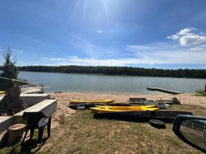 a group of kayaks on a beach next to a lake at Nad Sunowem Lake House in Chrzanowo +62 photos