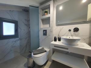 a white bathroom with a sink and a toilet at Sealon Suite & Loft in Limenaria +45 photos