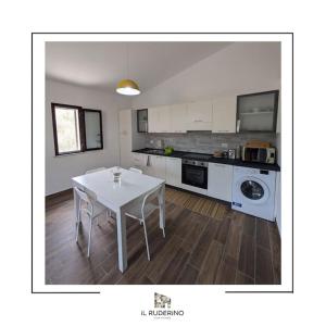 a kitchen with a white table and a white counter top at Il Ruderino in Melito di Porto Salvo