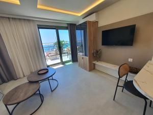 a living room with two chairs and a television at Sealon Suite & Loft in Limenaria