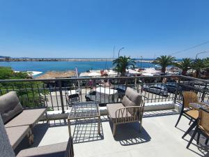 a balcony with chairs and tables and a view of a marina at Sealon Suite & Loft in Limenaria