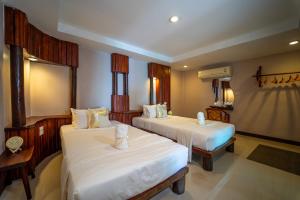 a hotel room with two beds and a mirror at Dusit Buncha Koh Tao by Riya Group in Ko Tao