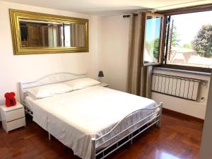 a bedroom with a bed and a mirror and a window at Maison Martina in Ariccia
