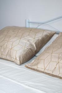 a bed with two brown pillows on it at Maison Martina in Ariccia
