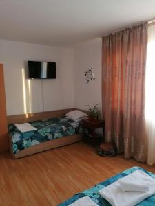 Un dormitorio con una cama y un televisor en una habitación. en Апартаменти Захариеви 4, en Byala