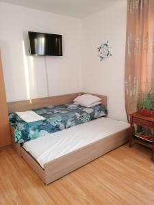 Cama en habitación con TV en la pared en Апартаменти Захариеви 4, en Byala
