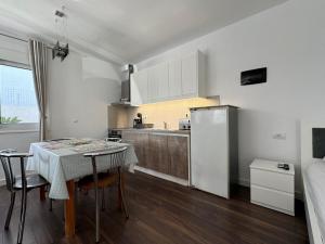 a small kitchen with a table and a refrigerator at Sulozeqi Apartments in Ksamil