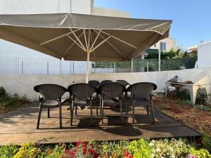 a table and chairs under a large umbrella at Sulozeqi Apartments in Ksamil +7 photos