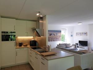 a kitchen with a sink and a couch in a room at Ferienparadies Seeluft in Kamperland