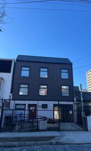 a black building with a fence in front of it at Hostal Ayiwün in Concepción