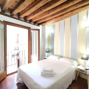 een slaapkamer met een wit bed en een groot raam bij Apartamento Tres Culturas Lux in Toledo