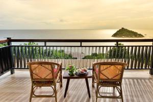 two chairs and a table on a balcony with the ocean at Dusit Buncha Koh Tao by Riya Group in Ko Tao