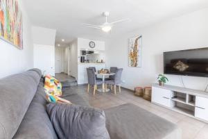 ein Wohnzimmer mit Couch und ein Esszimmer in der Unterkunft Oceanfront Apartment Parque Santiago II in Playa de las Americas