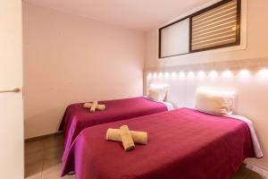 zwei Betten in einem Zimmer mit zwei Handtüchern darauf in der Unterkunft Oceanfront Apartment Parque Santiago II in Playa de las Americas + 28 Fotos