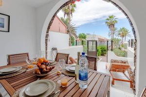 einen Tisch mit Speisen und Getränken auf der Terrasse in der Unterkunft Oceanfront Apartment Parque Santiago II in Playa de las Americas