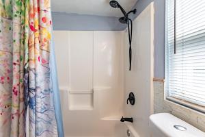 a bathroom with a shower curtain and a sink at Family-Friendly 2BR Cottage Near Creve Coeur Lake in Maryland Heights +21 photos