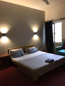 a bedroom with a bed with two pillows and a window at Durrani Lodges - G11 Islamabad in Islamabad