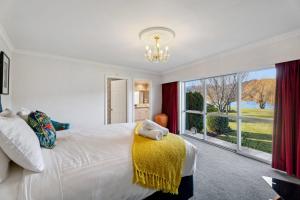 a bedroom with a large bed and a large window at Mount Pisa Lake View in Cromwell