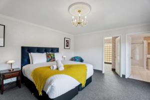a bedroom with a bed and a chandelier at Mount Pisa Lake View in Cromwell +26 photos