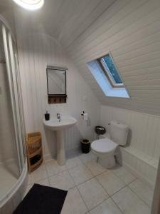 a bathroom with a sink and a toilet and a window at Au Pti' Bonheur in Saint-Coulomb