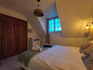 a bedroom with a large bed with towels on it at Au Pti' Bonheur in Saint-Coulomb