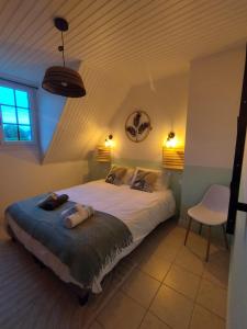 a bedroom with a bed with two pillows on it at Au Pti' Bonheur in Saint-Coulomb