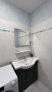 a white bathroom with a sink and a mirror at Appartement climatisé avec parking à Albi in Albi