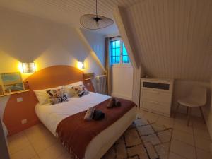 a bedroom with a large bed with shoes on it at Au Pti' Bonheur in Saint-Coulomb