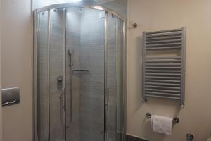 een douche met een glazen deur in de badkamer bij Trevi Palace Luxury Inn in Rome
