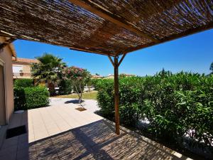 a view of a patio with a straw umbrella at Gîte Soleil in Adissan
