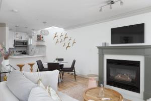 a living room with a couch and a fireplace at Boutique Beach Apartment in Vancouver