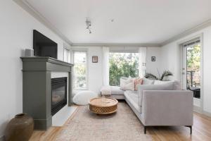 a living room with a couch and a fireplace at Boutique Beach Apartment in Vancouver
