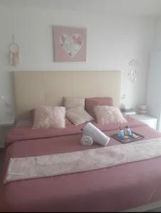 a large pink bed with pink sheets and pillows at Love Room Séduction in Tremblay En France