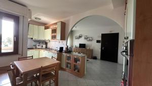 a kitchen with a table and a dining room at Poetto Casa Bach Ck in Quartu SantʼElena