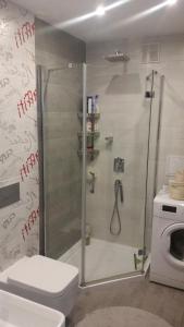 a bathroom with a shower with a toilet and a washing machine at Apartament na Uboczu in Wągrowiec