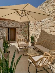 Un patio con una mesa y sillas y una sombrilla. en Hercules Home Malia, en Malia