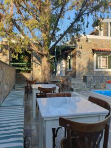 a patio with tables and chairs and a pool at Elia Village by Irida Iris Group in Plomari